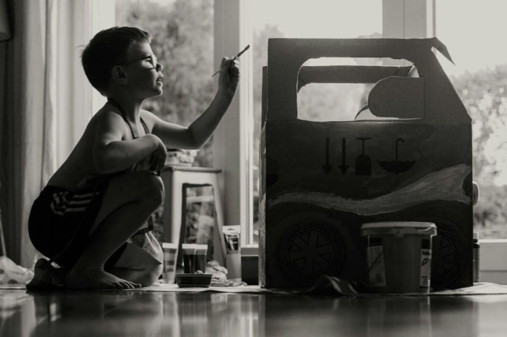 The boy plays on the floor in the house